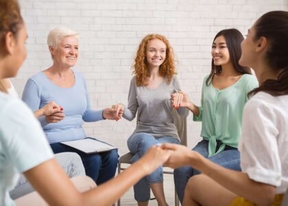 group-therapy-session-women-only-hold-hands-smiling